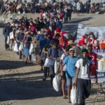 La Policía usa gas lacrimógeno durante el reparto de alimentos a los migrantes en la playa ceutí del Trampolín