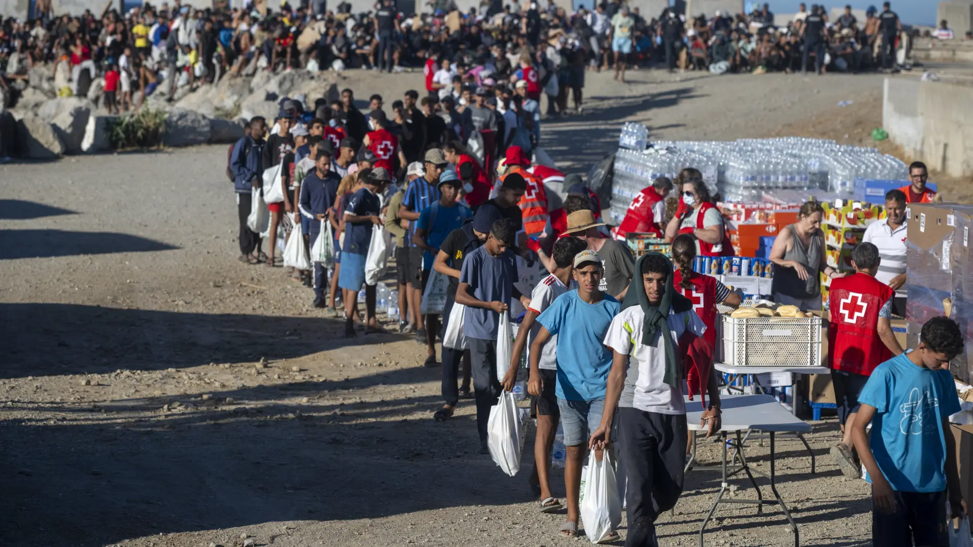 La Policía usa gas lacrimógeno durante el reparto de alimentos a los migrantes en la playa ceutí del Trampolín